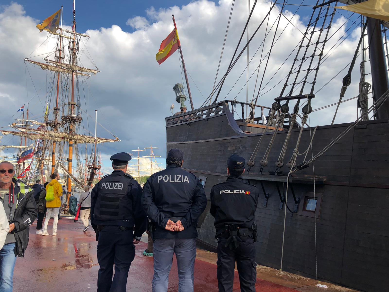 Policia Nacional amb agents d'altres països uniformats enfront de barca amb bandera espanyola.